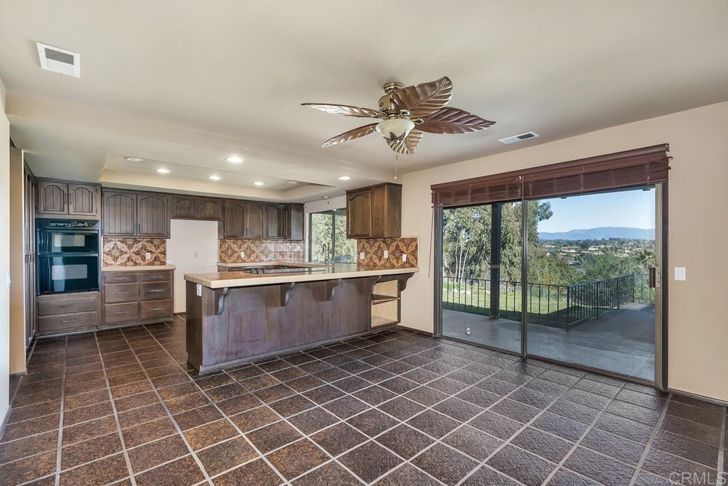 2527 Olive Hill Lane Fallbrook, CA 92028 - Photo 5 of 12 a large white kitchen with a large window and cabinets