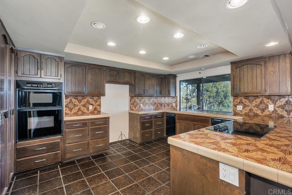 2527 Olive Hill Lane Fallbrook, CA 92028 - Photo 6 of 12 a kitchen with kitchen island granite countertop a sink stove and refrigerator