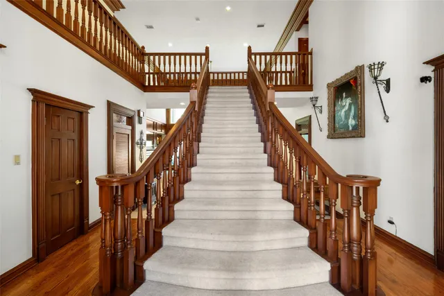 a view of staircase with lots of frames on wall and wooden floor