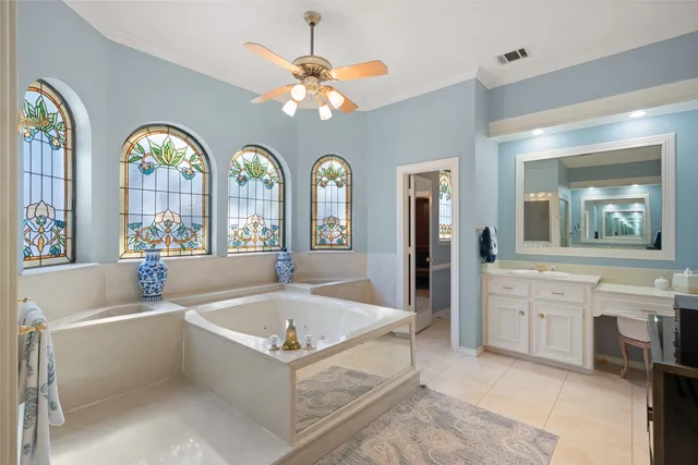 a spacious bathroom with a tub a double vanity sink a window and a mirror