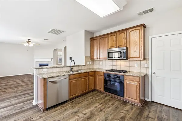 a kitchen with stainless steel appliances a refrigerator sink and cabinets