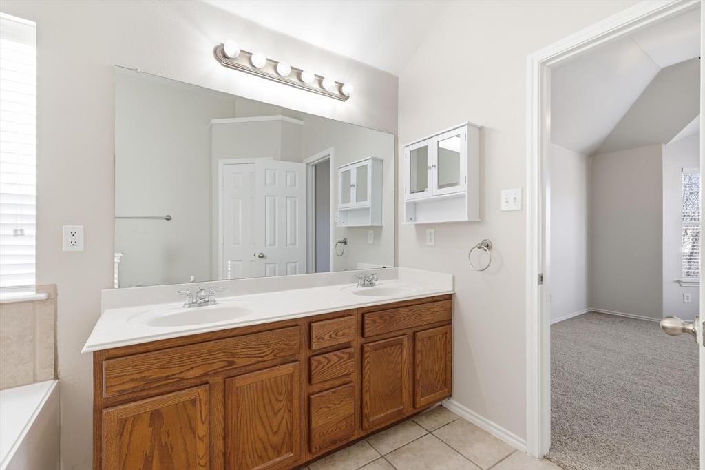 5229 Westheimer Road Fort Worth, TX 76244 - Photo 25 of 39 a bathroom with a sink a mirror and a shower