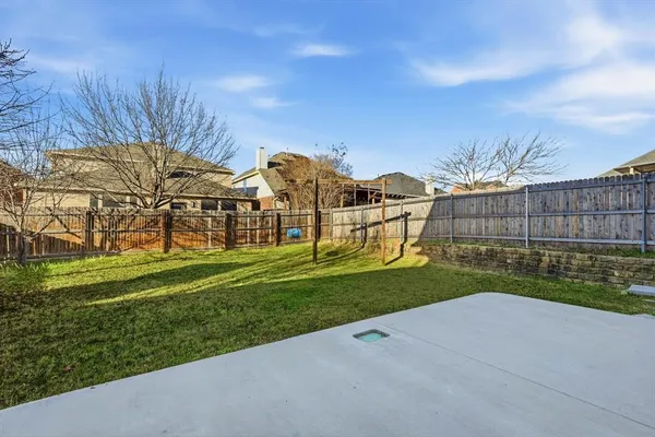 a view of a garden with a house in the background