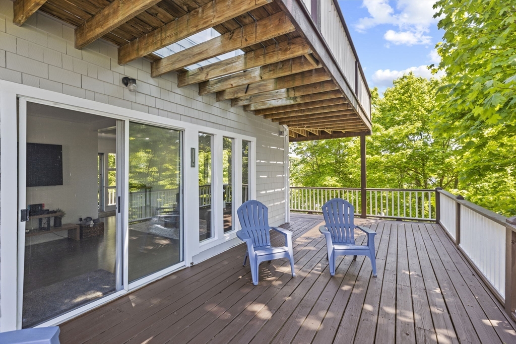 81 Ocean View Road Swampscott, MA 01907 - Photo 13 of 38 a view of a patio with table and chairs and wooden floor