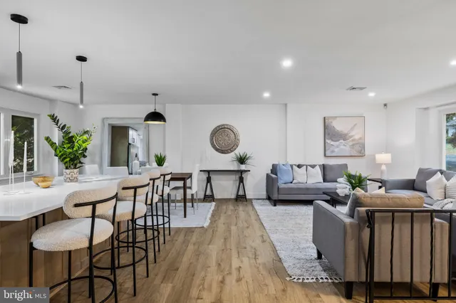 a kitchen with stainless steel appliances kitchen island granite countertop a dining table chairs and white cabinets