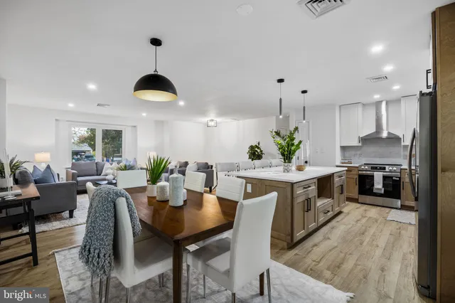 a kitchen with a dining table chairs refrigerator and cabinets