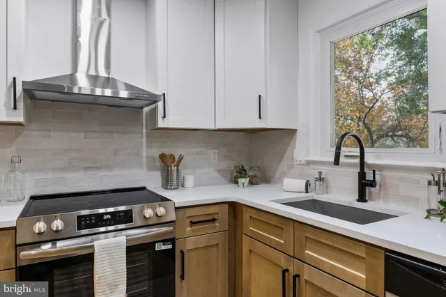 a kitchen with stainless steel appliances granite countertop a sink stove and cabinets