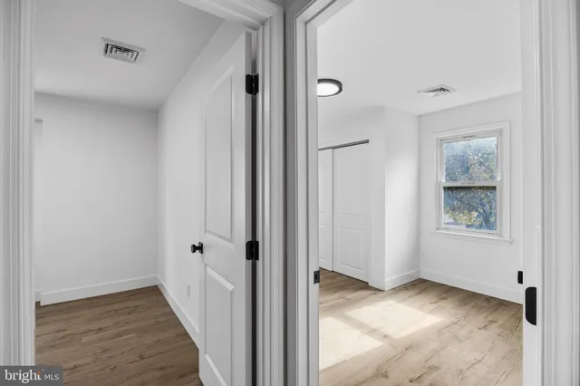 a view of empty room with wooden floor