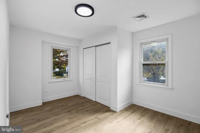 an empty room with wooden floor and window