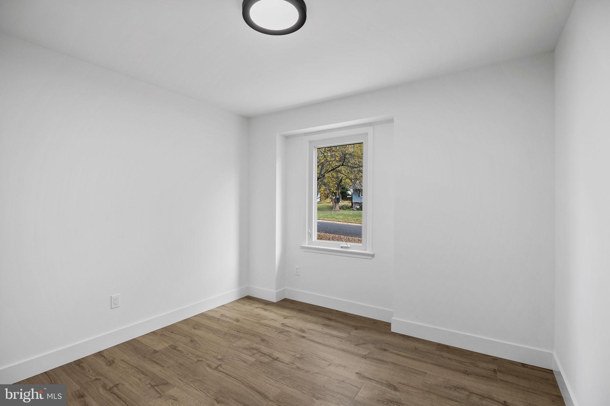 1189 Foxview Road Pottstown, PA 19465 - Photo 30 of 58 a view of an empty room with wooden floor and a window