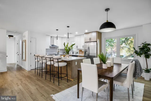 a dining room with furniture a chandelier and wooden floor