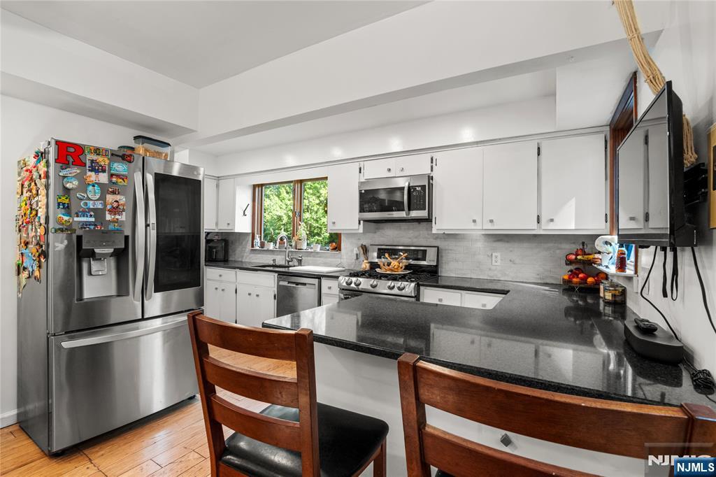 767-773 Ravine Road Plainfield, NJ 07062 - Photo 12 of 38 a kitchen with a refrigerator a stove a sink and chairs