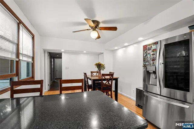 a view of a livingroom with furniture wooden floor and a ceiling fan