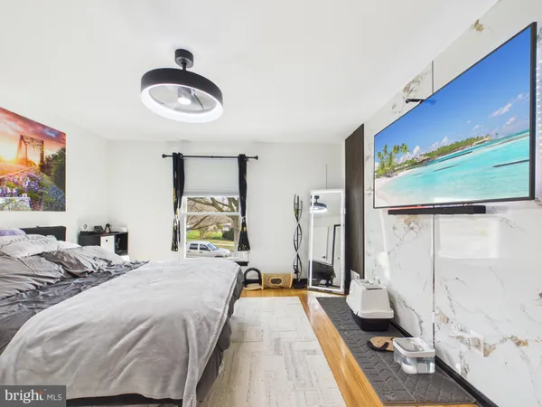 a bedroom with a bed and a flat tv screen on dresser