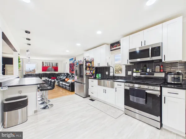 a kitchen with stainless steel appliances kitchen island granite countertop a stove and cabinets