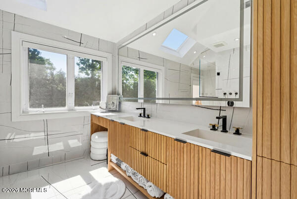54 Georgetown Road Eatontown, NJ 07724 - Photo 13 of 24 a bathroom with a sink mirror and a bathtub next to a window