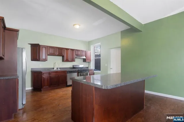 a kitchen with stainless steel appliances granite countertop a refrigerator a sink dishwasher a stove top oven a oven with granite countertops and cabinets