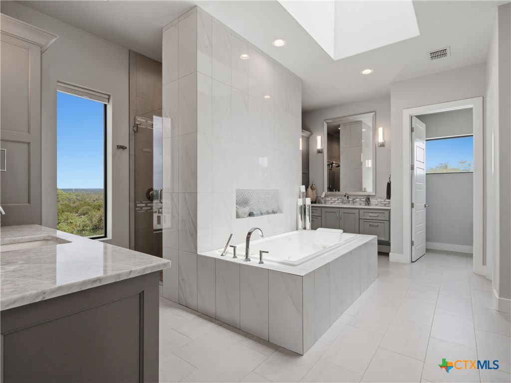 5913 Verden Ridge New Braunfels, TX 78132 - Photo 15 of 48 a spacious bathroom with a tub double sink and mirror