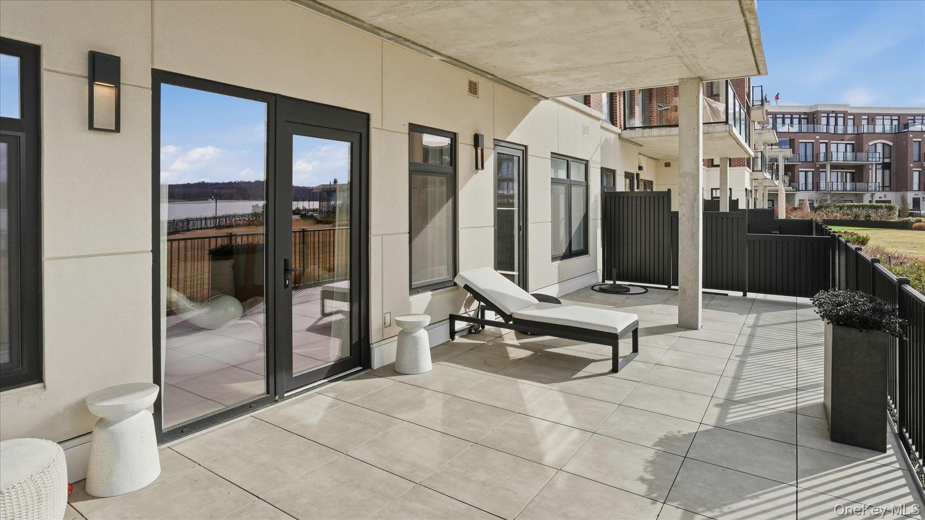 10 Shore Road, Unit 108 Glenwood Landing, NY 11547 - Photo 11 of 20 a building outdoor space with patio furniture and glass door