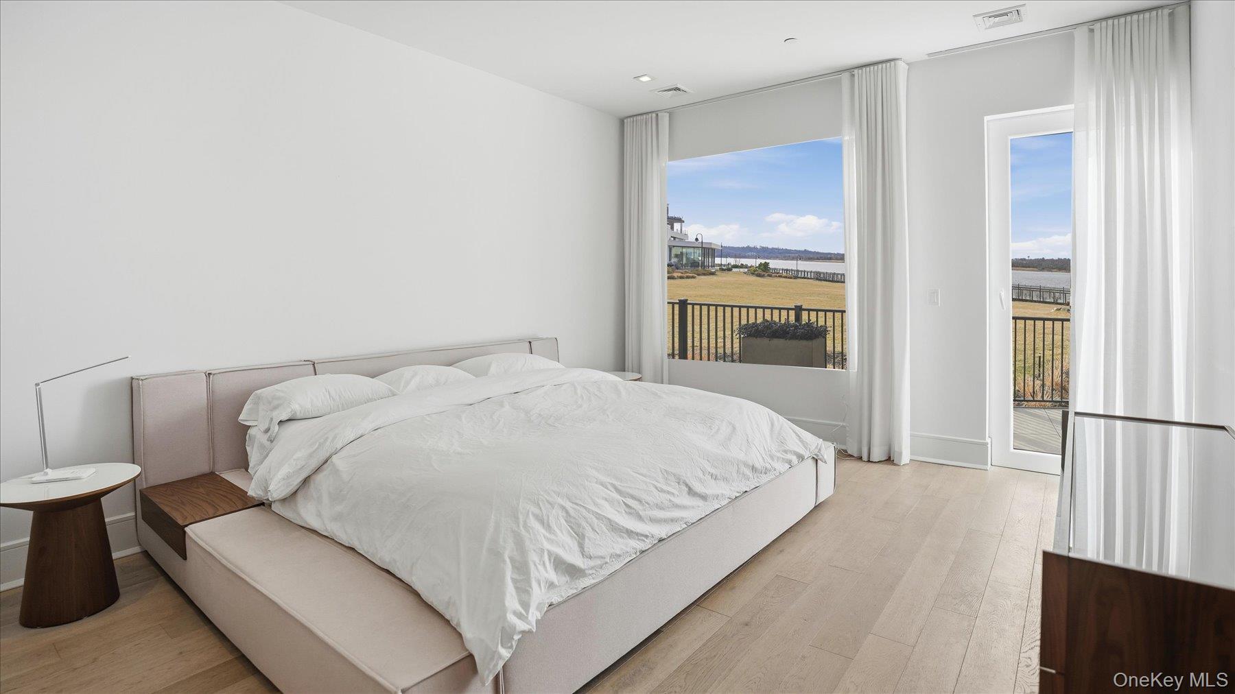 10 Shore Road, Unit 108 Glenwood Landing, NY 11547 - Photo 9 of 20 a large white bed in a white room