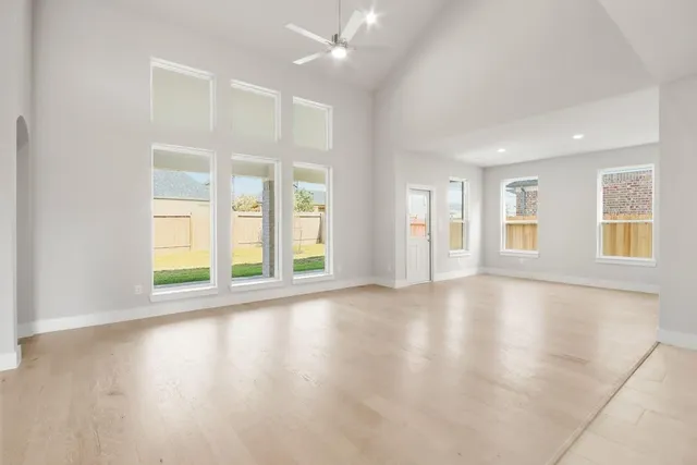 a view of an empty room with window and wooden floor