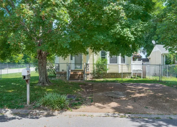 a view of a house with a yard and sitting area