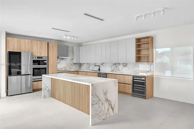 a kitchen with stainless steel appliances granite countertop a refrigerator and a stove top oven