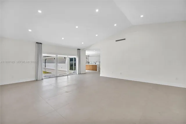 a view of a big room with wooden floor and windows
