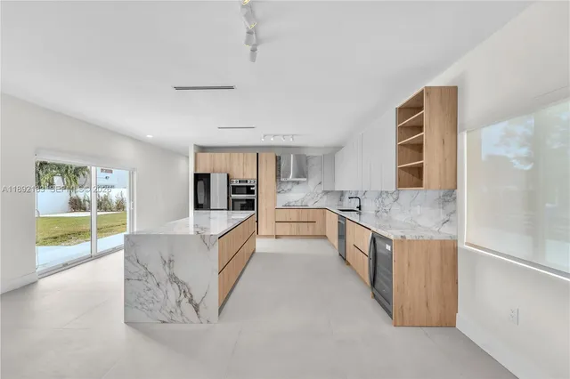 a large kitchen with stainless steel appliances granite countertop a large counter top and a stove