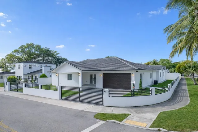 a front view of a house with a garden and plants