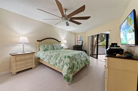 a bedroom with a bed a ceiling fan and a large mirror
