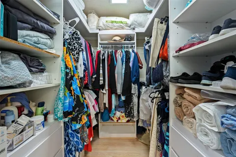 a view of walk in closet with clothes and shoes