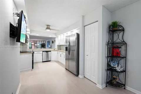 a kitchen with stainless steel appliances kitchen island a refrigerator sink and a stove