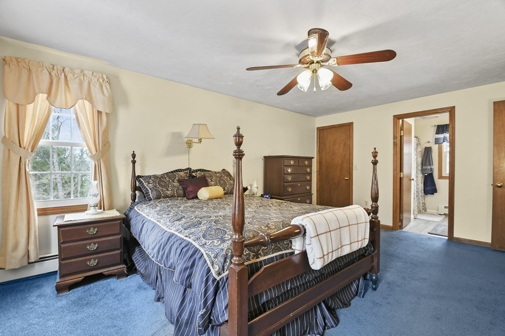 21 Merrill Road Sutton, MA 01590 - Photo 15 of 36 a bedroom with a bed and a chandelier