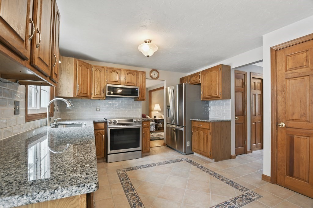 21 Merrill Road Sutton, MA 01590 - Photo 2 of 36 a kitchen with stainless steel appliances granite countertop a sink stove and refrigerator
