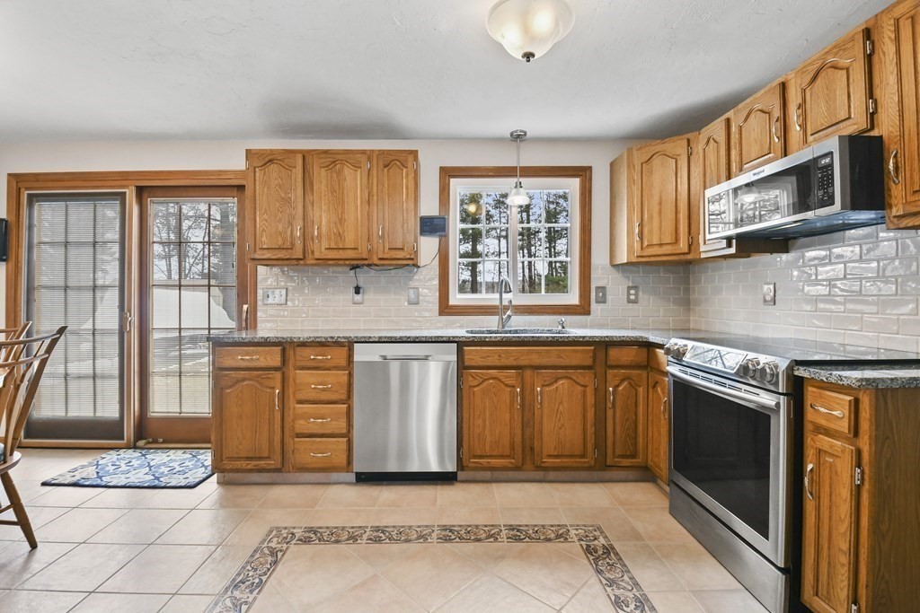 21 Merrill Road Sutton, MA 01590 - Photo 3 of 36 a kitchen with stainless steel appliances granite countertop a stove sink and cabinets