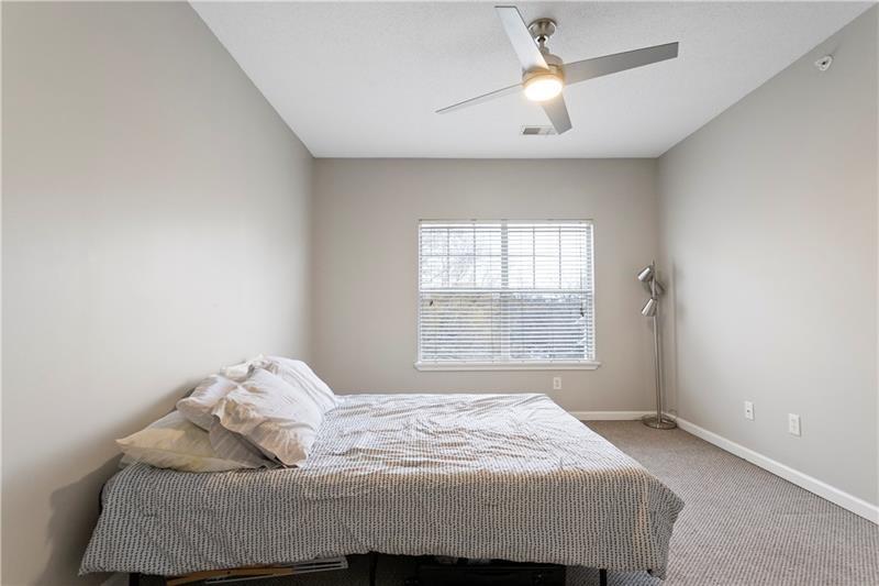 1150 Collier Road Northwest, Unit 3P Atlanta, GA 30318 - Photo 18 of 24 a bedroom with a bed and a chandelier