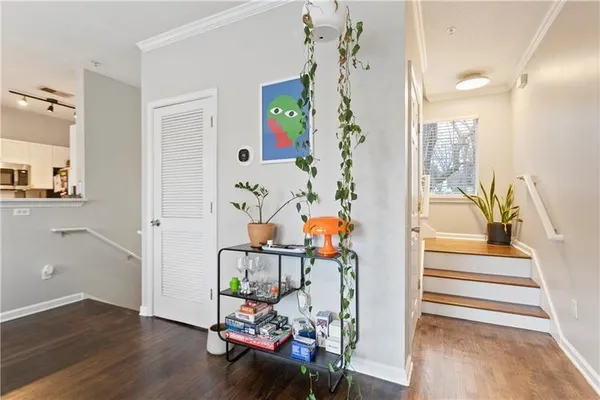 a view of a hallway with wooden floor and dining area