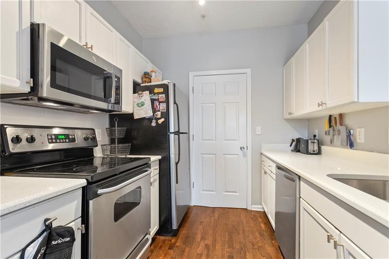 1150 Collier Road Northwest, Unit 3P Atlanta, GA 30318 - Photo 7 of 24 a kitchen with stainless steel appliances a stove microwave and sink