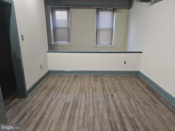 a view of a room with wooden floor and window