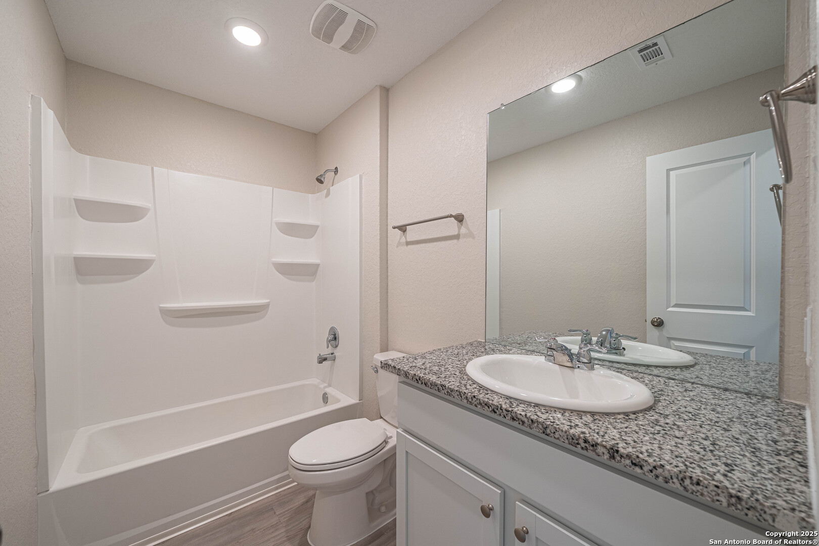 2818 Gustavo Drive Converse, TX 78109 - Photo 24 of 27 a bathroom with a granite countertop sink a toilet and shower