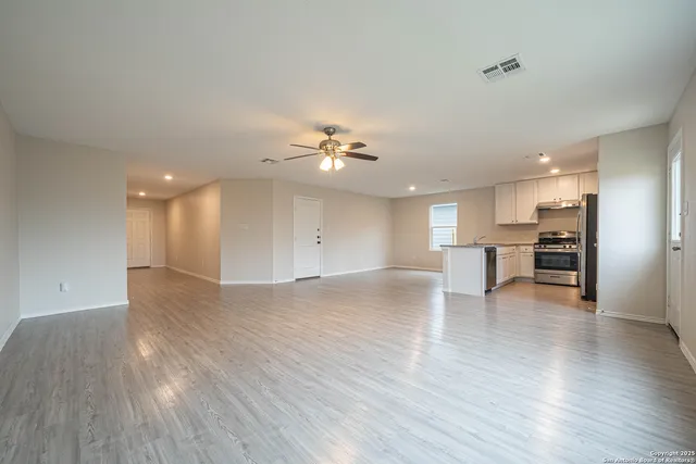 a view of a kitchen with a sink a refrigerator and wooden floor