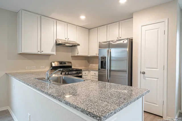 a kitchen with stainless steel appliances granite countertop a stove and a refrigerator