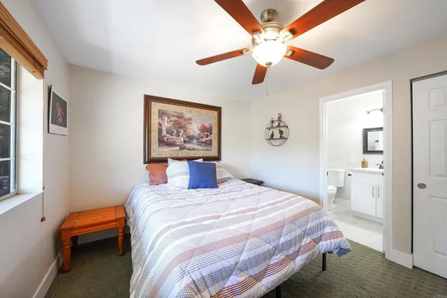 a bathroom with a granite countertop toilet a sink and a mirror