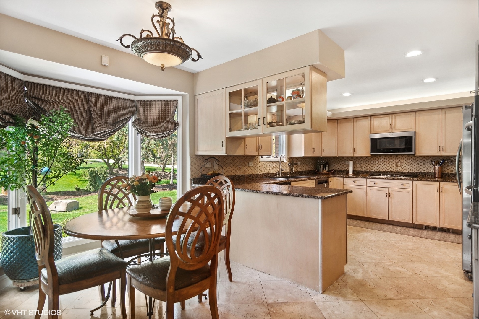 6207 Pine Tree Drive Long Grove, IL 60047 - Photo 16 of 49 a kitchen with stainless steel appliances granite countertop a stove top oven a sink a dining table and chairs with wooden floor