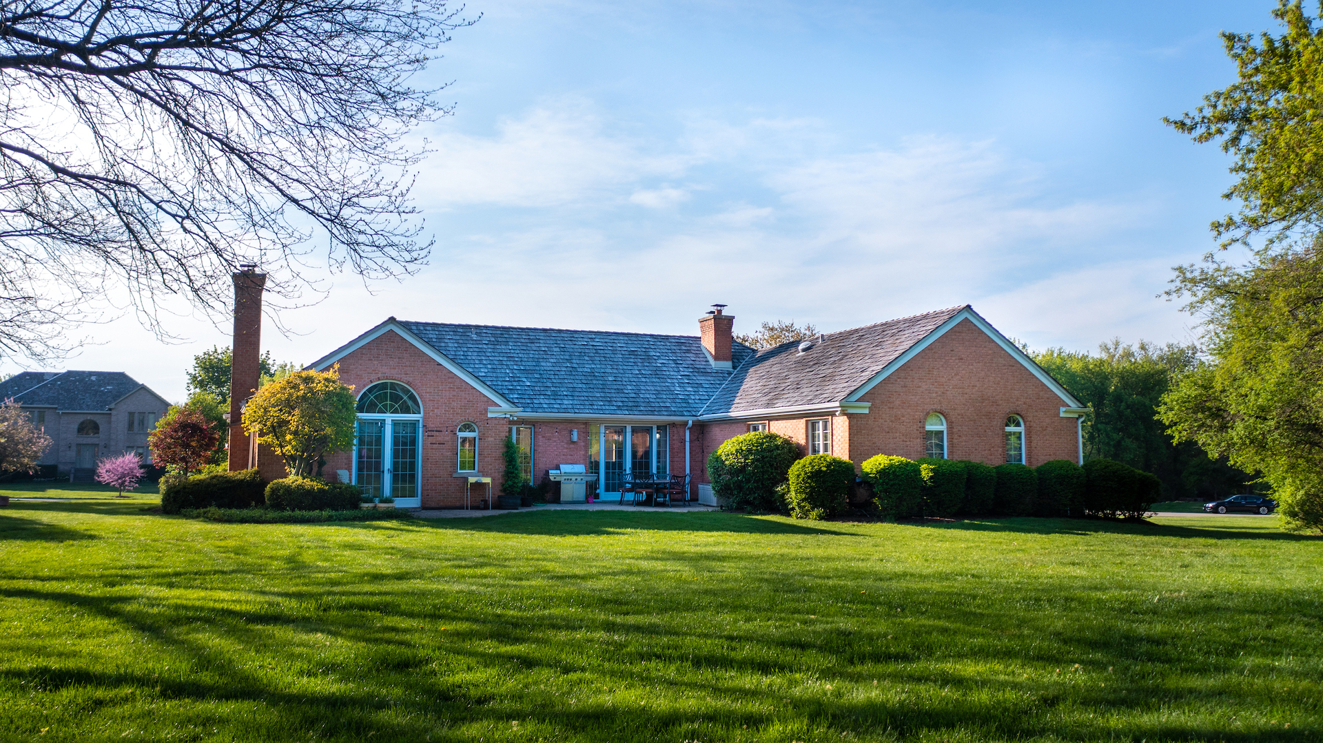 6207 Pine Tree Drive Long Grove, IL 60047 - Photo 39 of 49 a front view of a house with a yard table and chairs