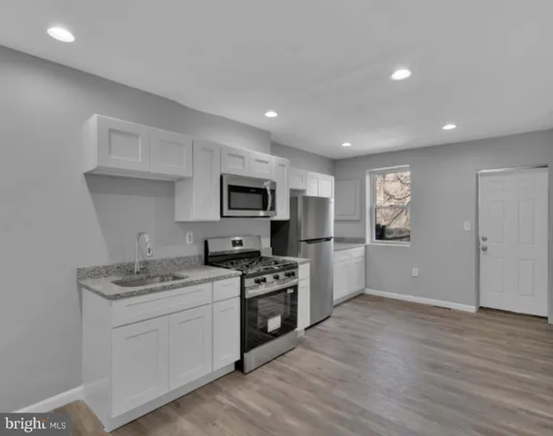 a kitchen with stainless steel appliances kitchen island granite countertop a stove a sink and a microwave