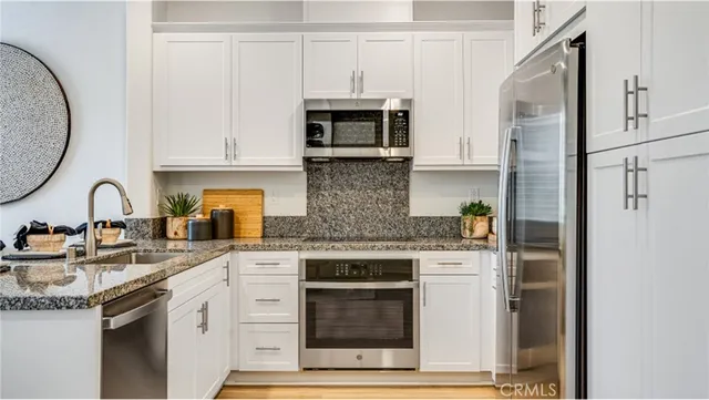 a kitchen with stainless steel appliances granite countertop a stove and a refrigerator