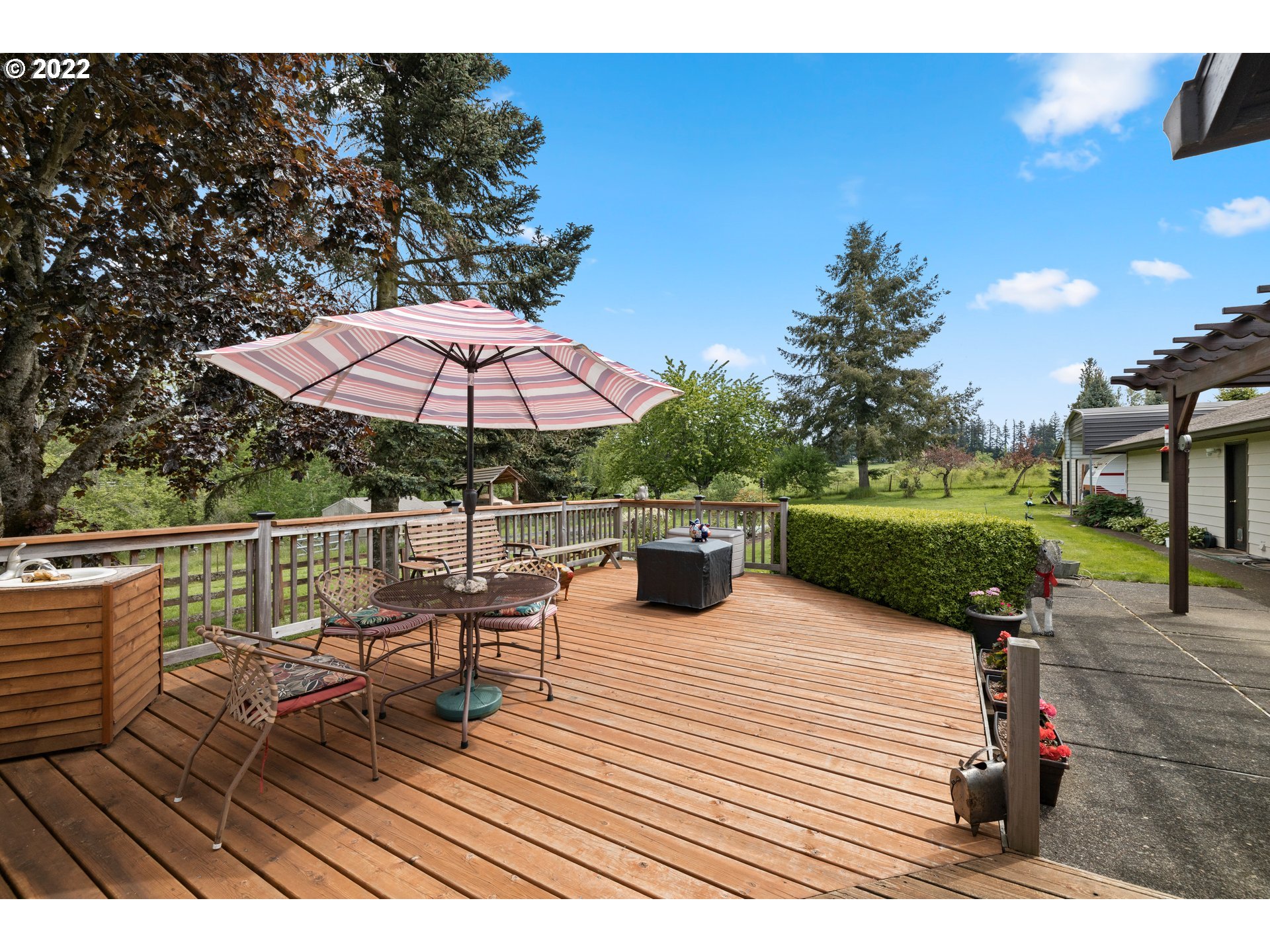 13565 South Carus Road Oregon City, OR 97045 - Photo 5 of 32 a view of a roof deck with table and chairs under an umbrella with wooden floor