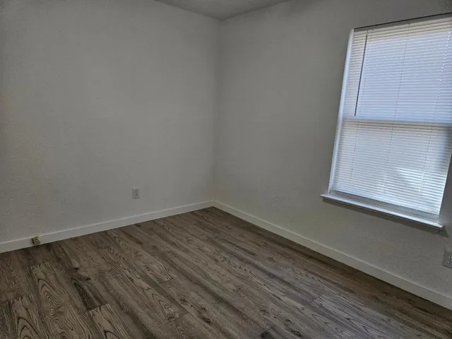 a view of a small space with wooden floor and a window